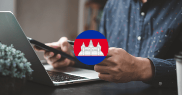  Persoon werkt op laptop en smartphone met Cambodjaanse vlag in beeld, symbool voor digitalisering van belastingprocessen in Cambodja