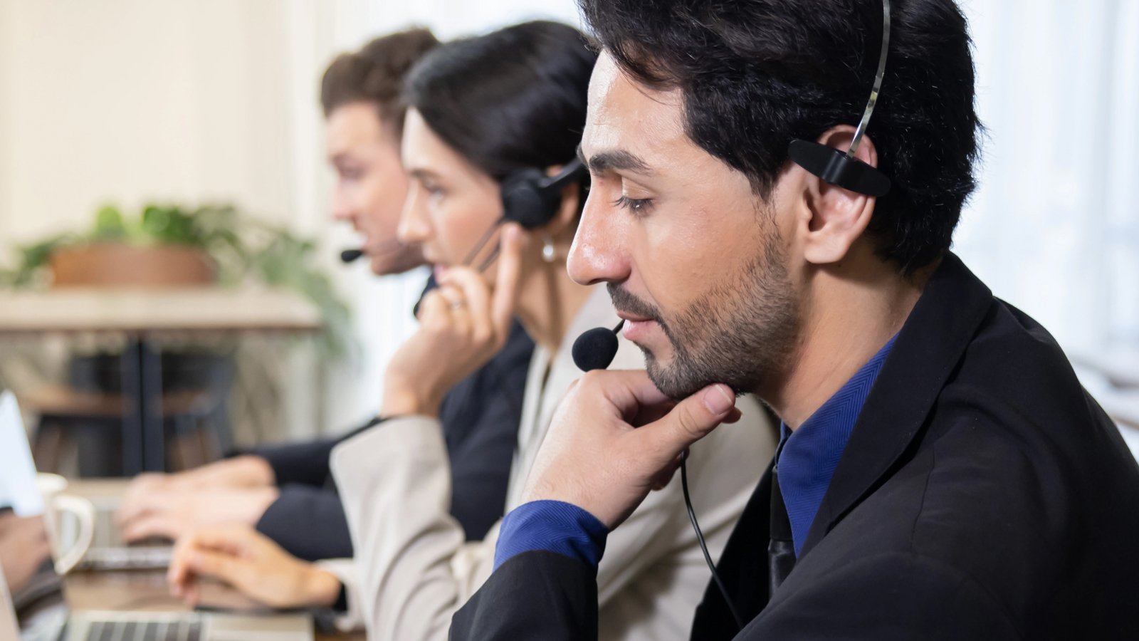 Klantenservicemedewerkers met headsets voeren Customer Assessments en Credit Checks uit op kantoor.