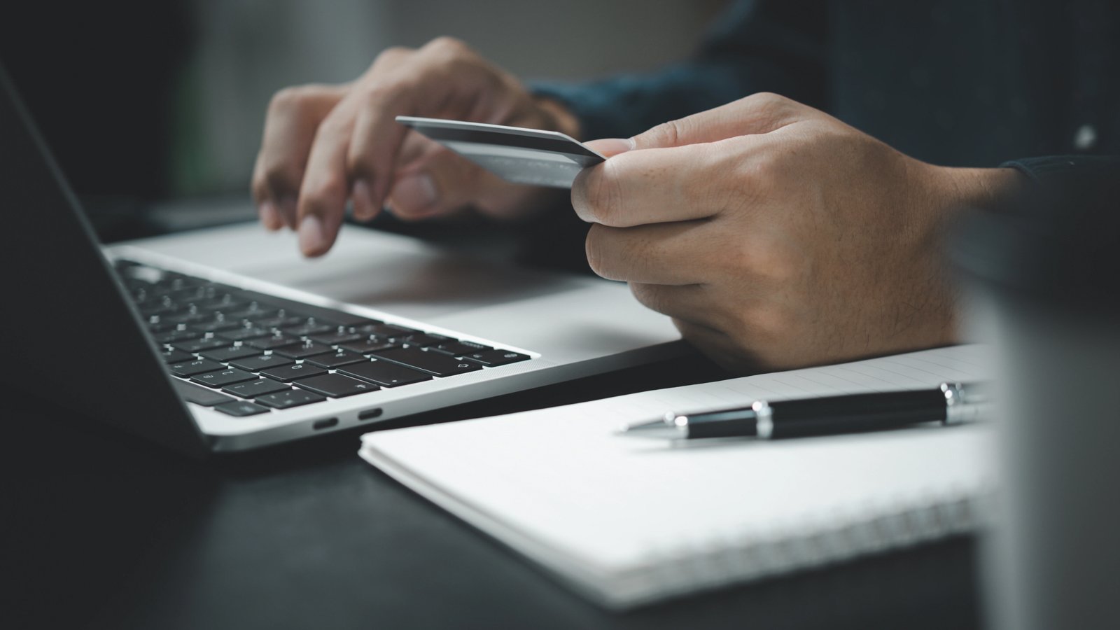 Persoon voert een betaling uit met bankpas op laptop, passend bij Direct Debit (SEPA eMandates) en geautomatiseerde betalingen